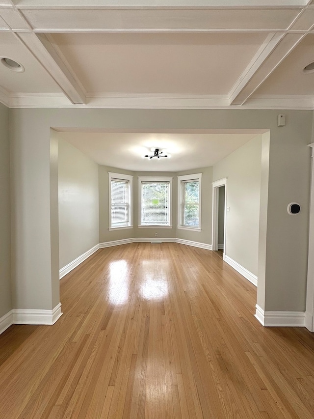 unfurnished room with beam ceiling and light hardwood / wood-style floors