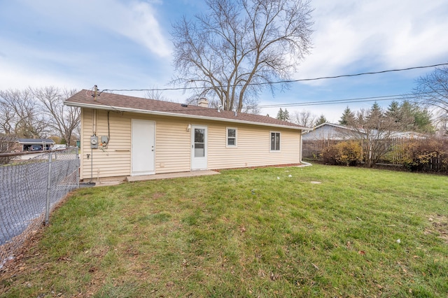 rear view of property with a yard