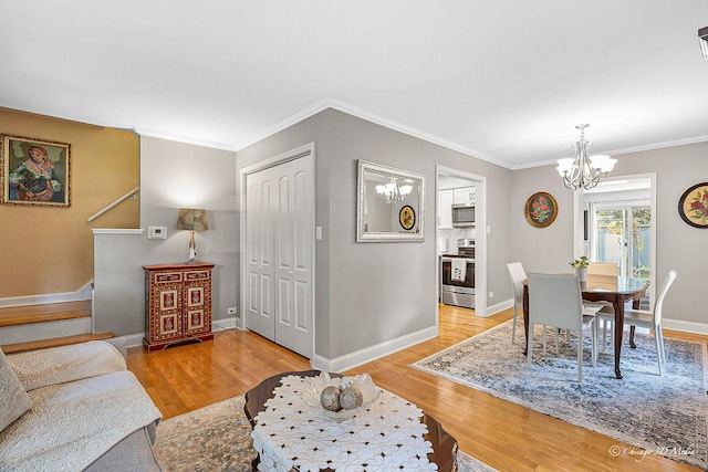 dining area with crown molding, baseboards, stairway, light wood-type flooring, and a notable chandelier