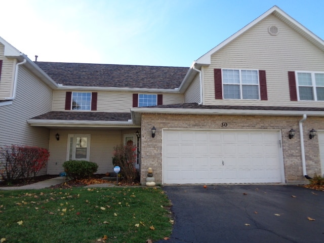 view of property with a garage and a front yard