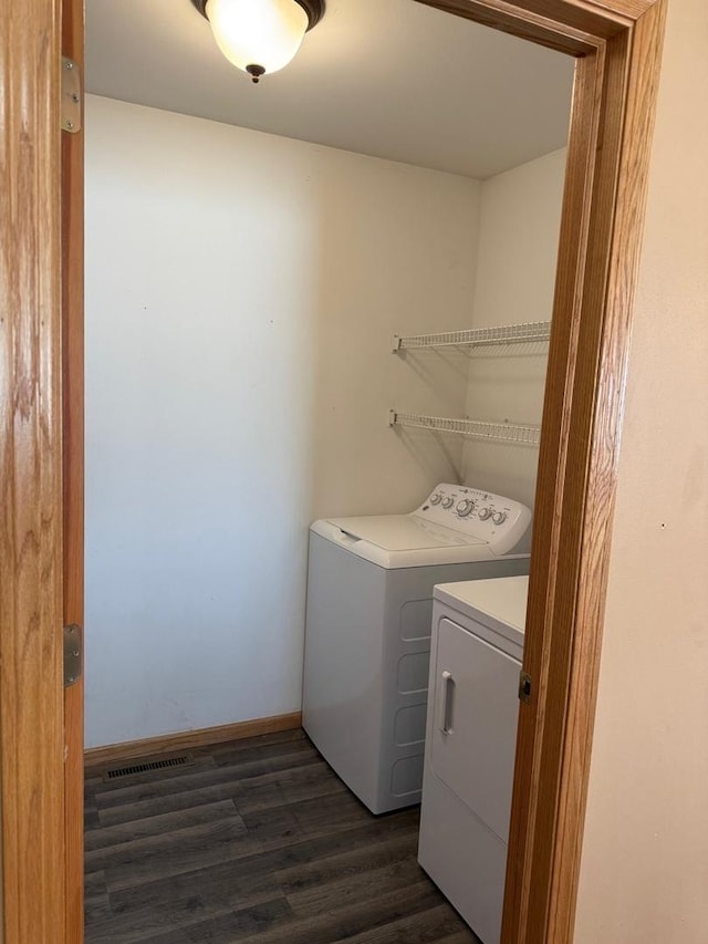 clothes washing area featuring separate washer and dryer and dark hardwood / wood-style flooring