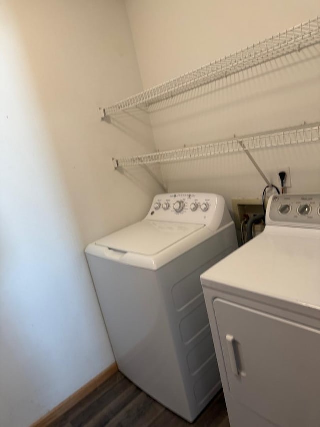 clothes washing area featuring washer and dryer and dark hardwood / wood-style floors