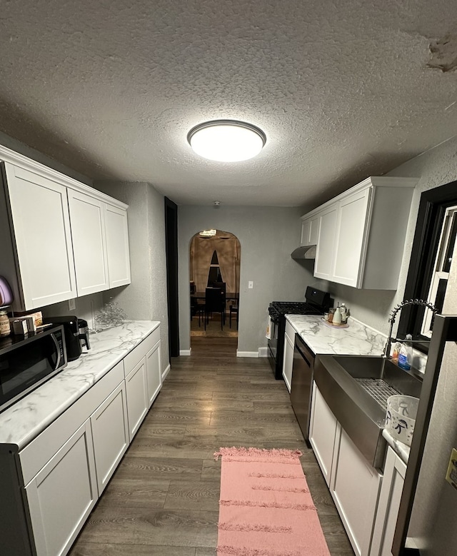 kitchen with white cabinetry, dark hardwood / wood-style flooring, stainless steel appliances, and a textured ceiling