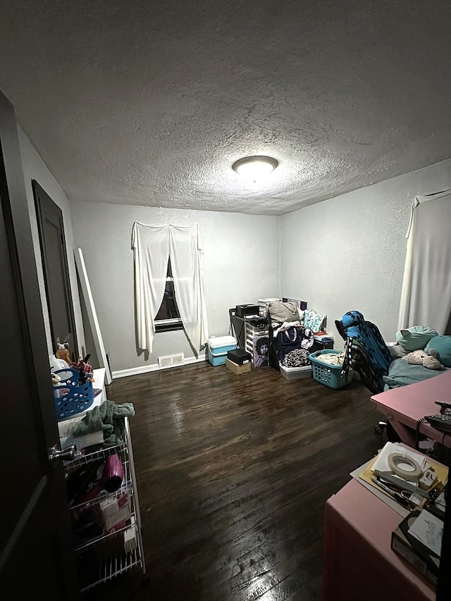 misc room featuring dark wood-type flooring and a textured ceiling