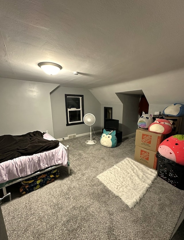 bedroom with a textured ceiling, carpet floors, and lofted ceiling