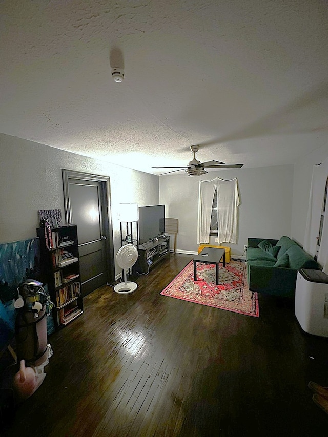 living room featuring a textured ceiling, dark hardwood / wood-style floors, and ceiling fan