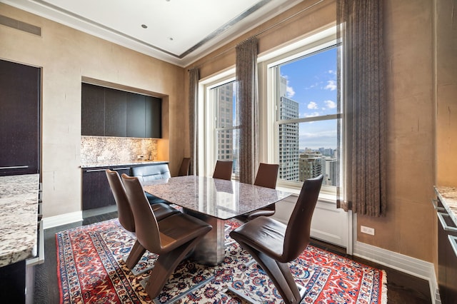 dining area featuring hardwood / wood-style flooring, a wealth of natural light, and ornamental molding