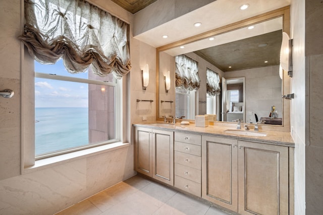 bathroom with tile patterned flooring, vanity, and a water view