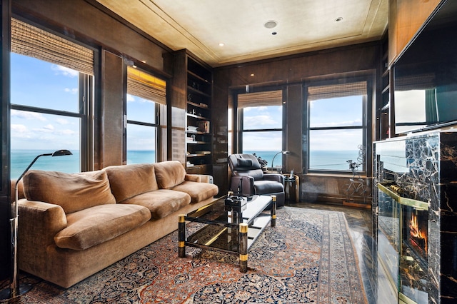 living room featuring crown molding, a wealth of natural light, and wooden walls