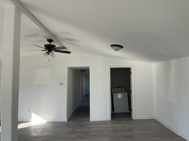 spare room with vaulted ceiling with beams, dark hardwood / wood-style floors, washer / dryer, and ceiling fan