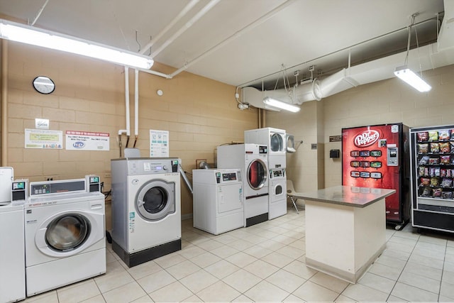 3041 S Michigan Ave Unit 504, Chicago, IL 60616 - shared laundry room featuring washer and clothes dryer, concrete block wall, stacked washer / drying machine, and light tile patterned floors