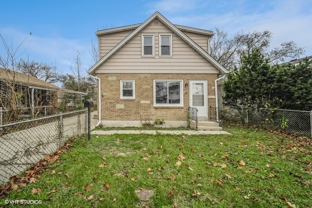 rear view of house featuring a yard