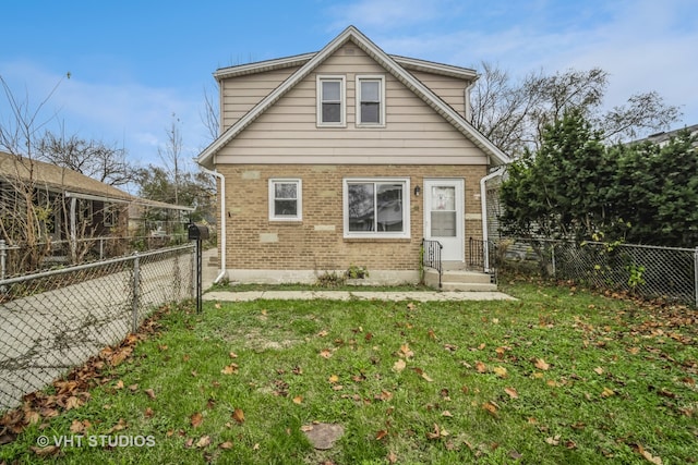 rear view of house featuring a yard