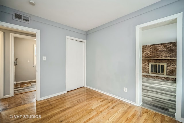 unfurnished living room with a fireplace and light hardwood / wood-style floors