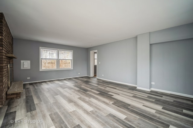 unfurnished living room featuring a fireplace and light hardwood / wood-style floors