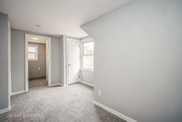 unfurnished bedroom with light colored carpet and multiple windows