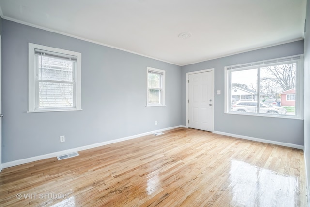 empty room with light hardwood / wood-style floors and a wealth of natural light