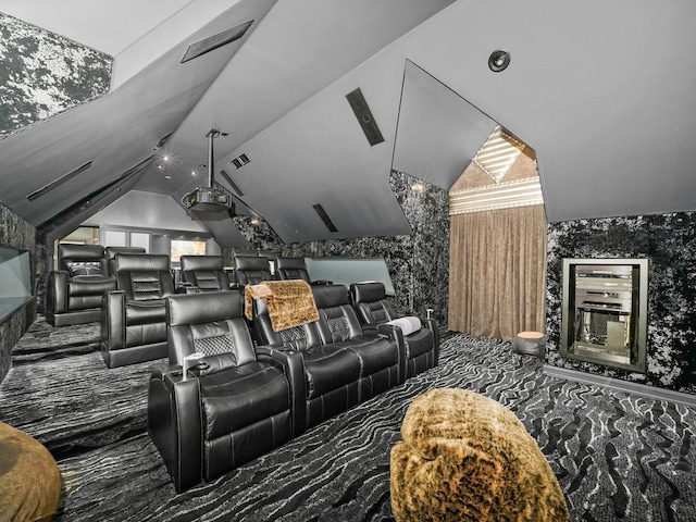 carpeted cinema room featuring lofted ceiling