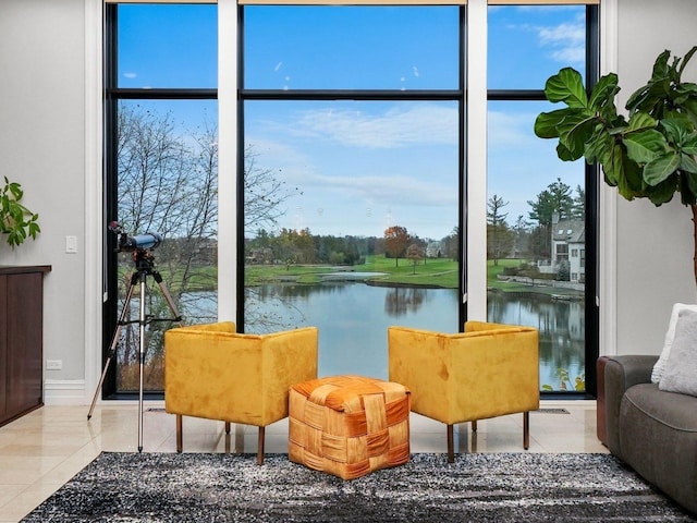 interior space with a water view, light tile patterned floors, and a wall of windows