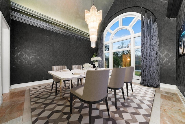 dining area with baseboards, a chandelier, a towering ceiling, and wallpapered walls