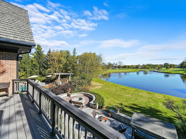 exterior space with a water view, a yard, a pergola, and a fire pit