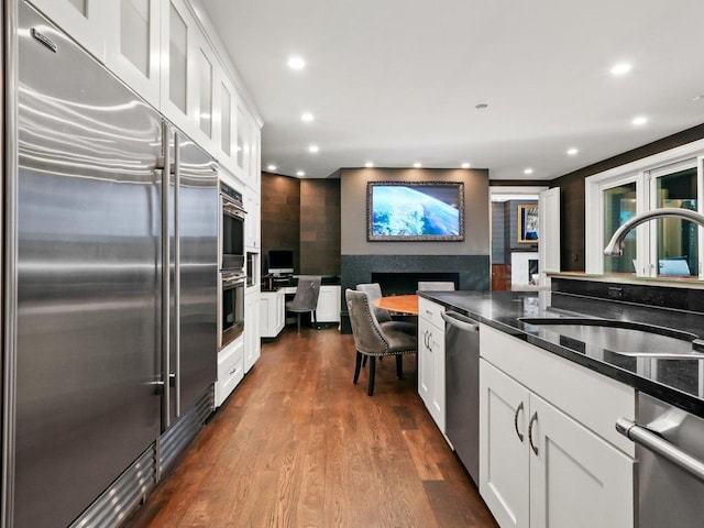 kitchen with appliances with stainless steel finishes, sink, dark wood-type flooring, and white cabinets