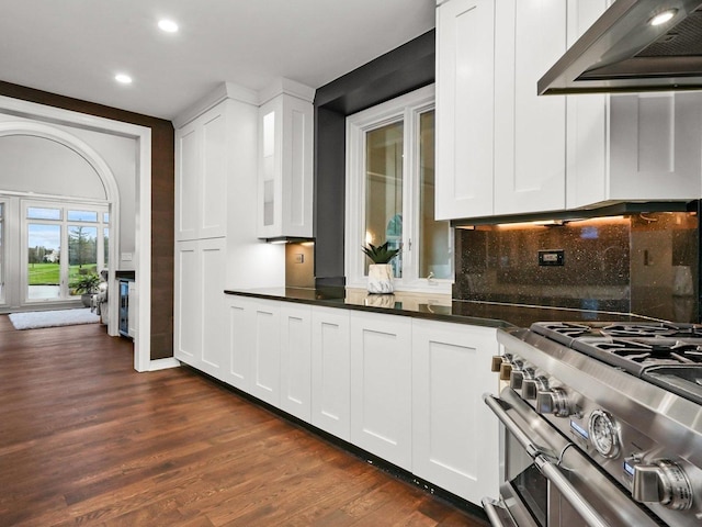 kitchen featuring dark wood-type flooring, white cabinetry, double oven range, custom range hood, and decorative backsplash