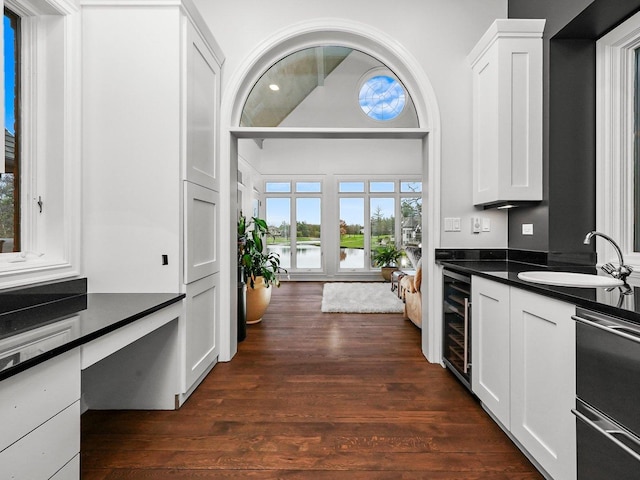 kitchen featuring dark hardwood / wood-style floors, sink, wine cooler, white cabinets, and stainless steel dishwasher