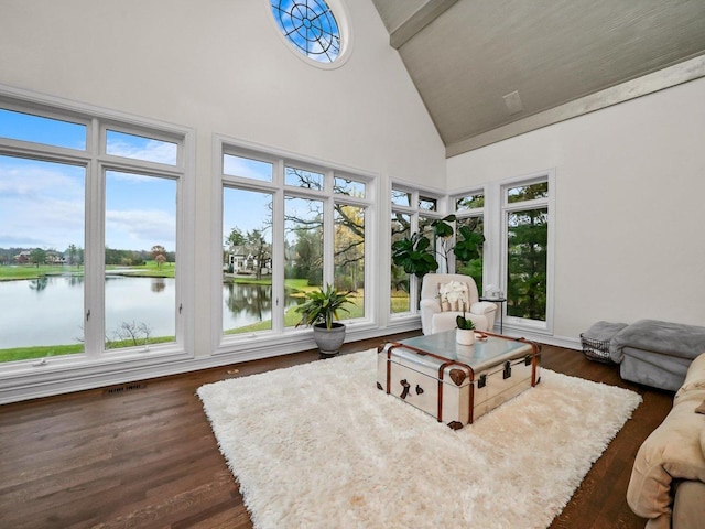 sunroom featuring vaulted ceiling and a water view