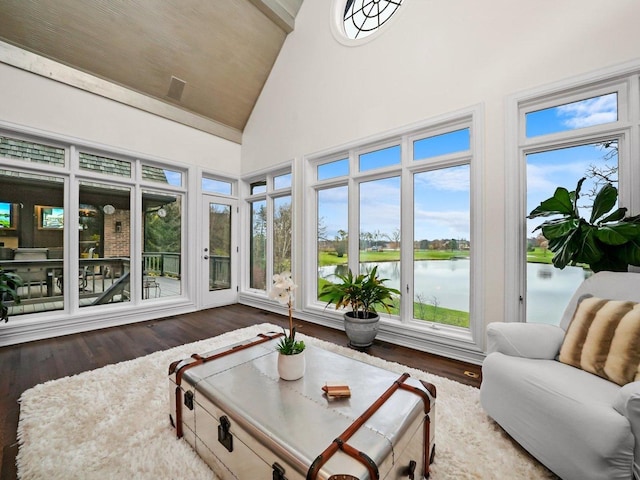 sunroom / solarium featuring vaulted ceiling and a water view