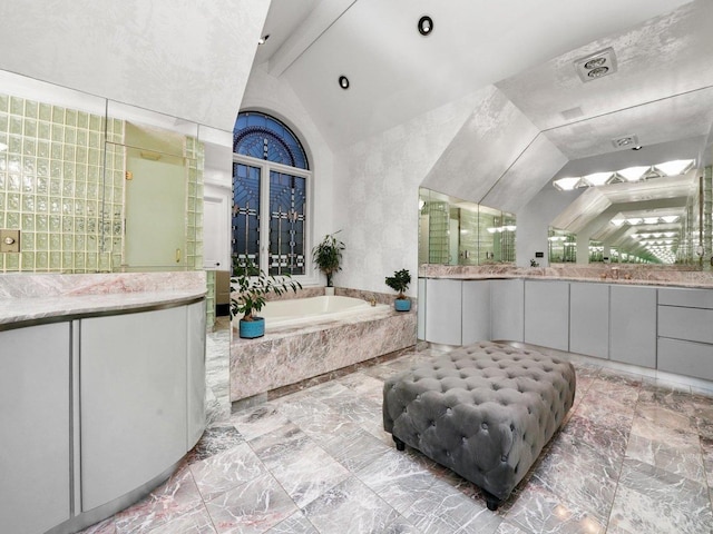 bathroom with vanity, independent shower and bath, and vaulted ceiling