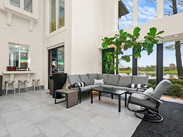 view of patio with a water view and outdoor lounge area