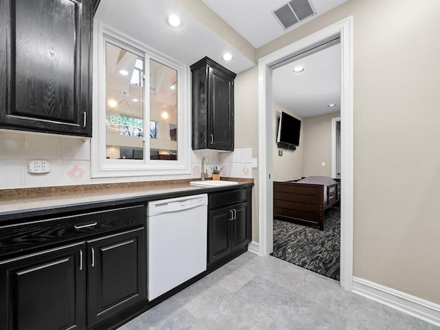 kitchen featuring white dishwasher, sink, and backsplash