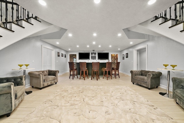 living room featuring bar and light wood-type flooring