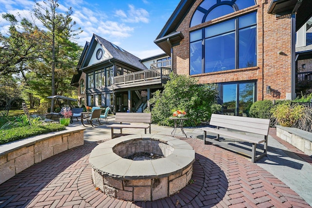 back of house with an outdoor fire pit and a patio