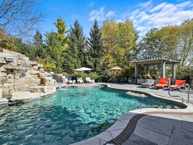 view of swimming pool featuring pool water feature, a patio area, and a pergola