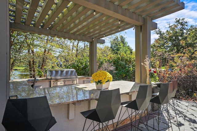 view of patio featuring a water view, grilling area, a pergola, an outdoor bar, and exterior kitchen