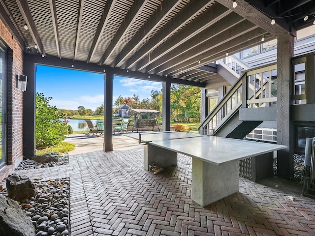 view of patio with a water view and an outdoor bar