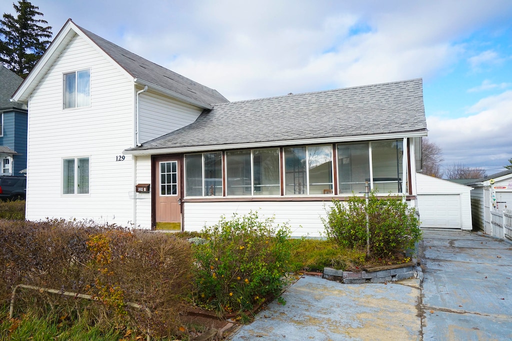 view of front of property with a garage and an outdoor structure