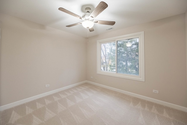 carpeted spare room with ceiling fan