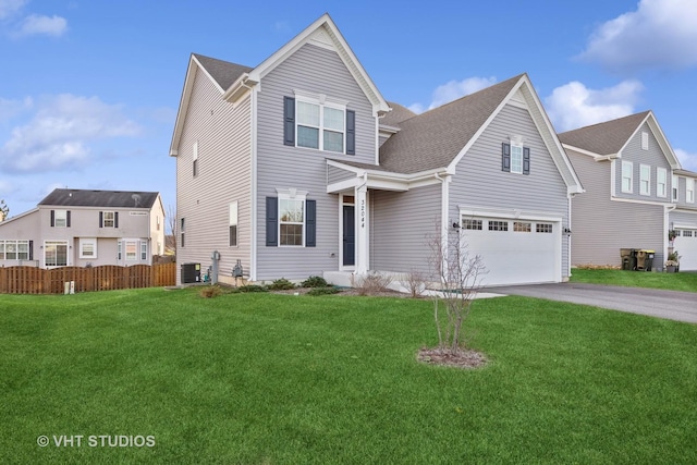 front facade featuring central AC, a front yard, and a garage