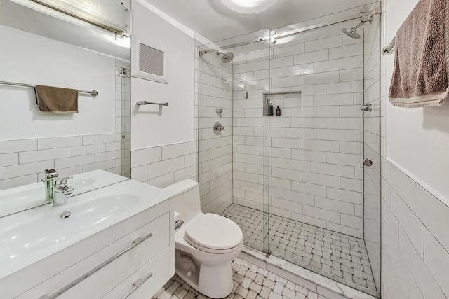 bathroom featuring walk in shower, vanity, tile walls, and toilet