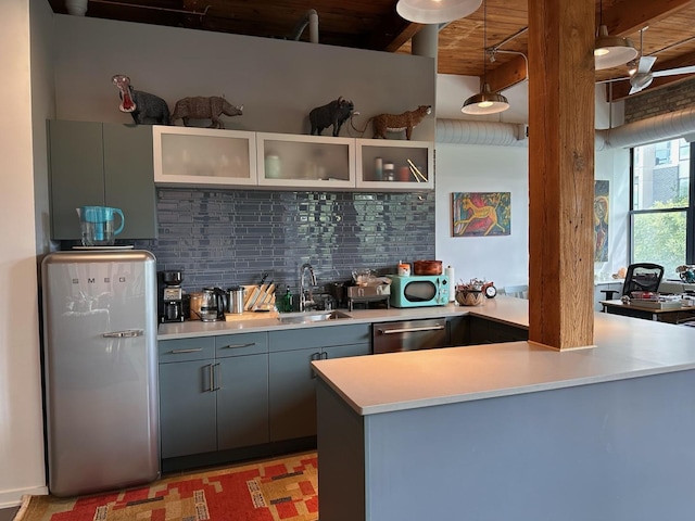 kitchen with backsplash, sink, beam ceiling, dishwasher, and hanging light fixtures