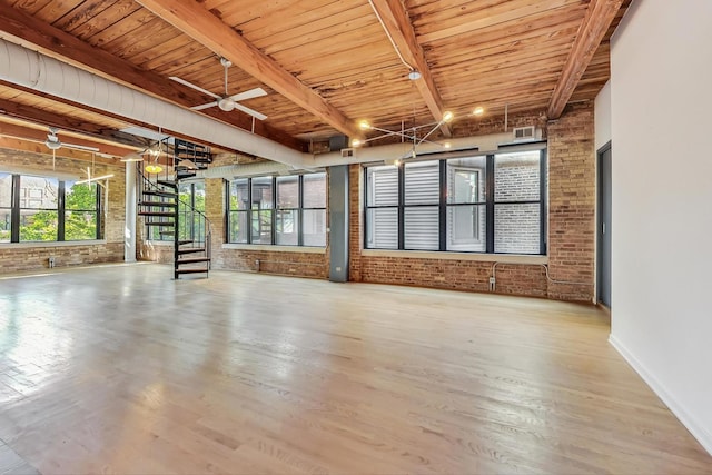 unfurnished room featuring beam ceiling, wood ceiling, ceiling fan, and brick wall