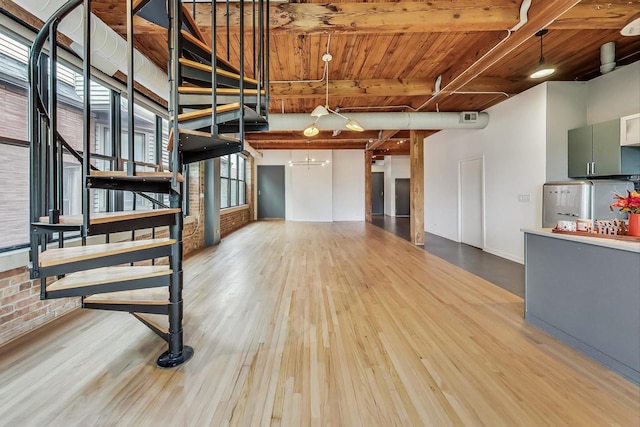 interior space featuring hardwood / wood-style floors, wood ceiling, and brick wall