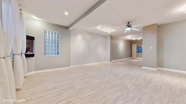 empty room with ceiling fan, light hardwood / wood-style flooring, and track lighting