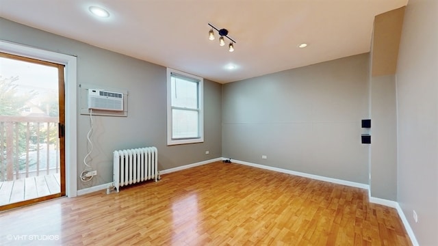 spare room with a healthy amount of sunlight, light wood-type flooring, and radiator