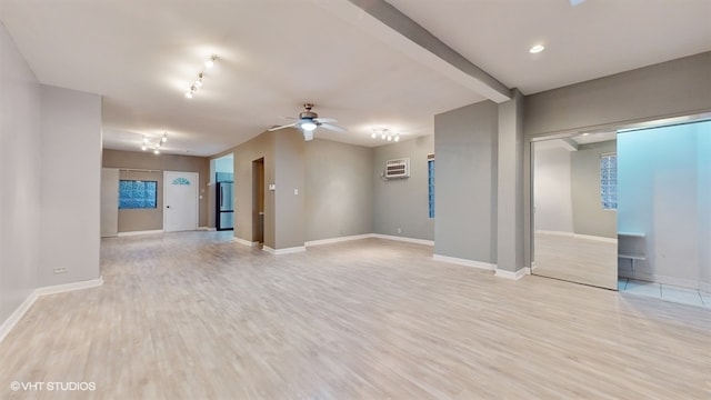 interior space featuring light wood-type flooring, an AC wall unit, and ceiling fan