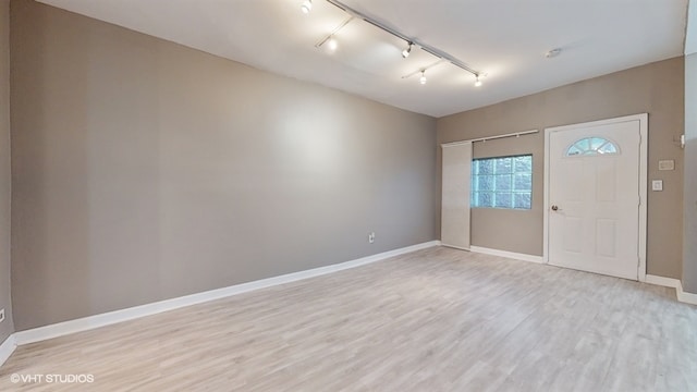 foyer entrance with light hardwood / wood-style floors and track lighting