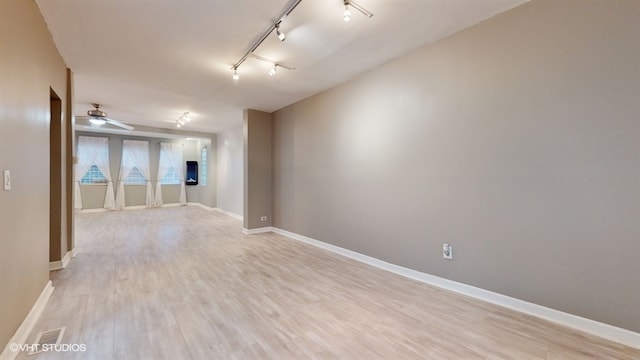 unfurnished room featuring ceiling fan, light hardwood / wood-style floors, and rail lighting